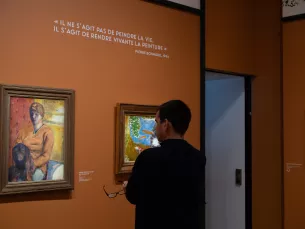 photo in situ de deux oeuvres de Bonnard sur fond orange avec un visiteur