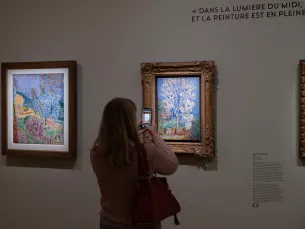 photo in situ des oeuvres L'Amandier en fleurs et Le Jardin de Bonnard avec une visiteuse en train de photographier L'Amandier